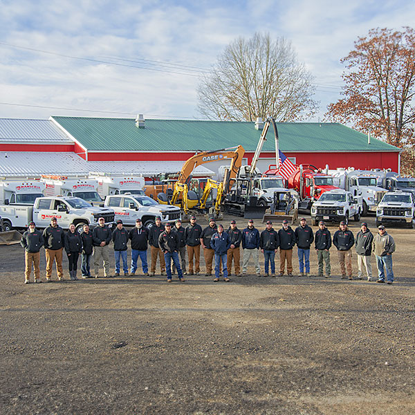 Our expert and knowledgable staff standing in front of septic service equipment at our office location in Edinboro, PA. 