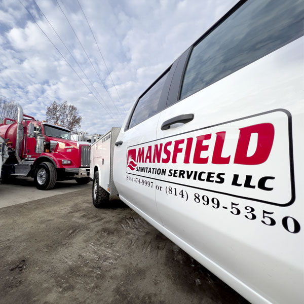 The side of a Mansfield Sanitation truck displaying the Mansfield Sanitation logo.