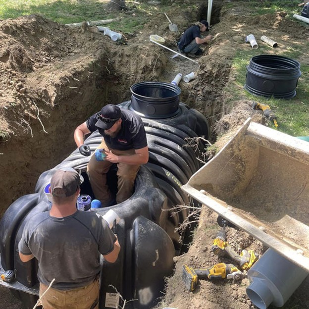 Two Mansfield Sanitation employees installing a septic system and drain field.
