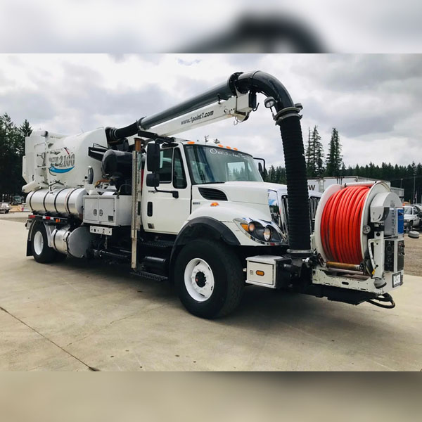 A Mansfield Sanitation truck with drain cleaning equipment and hoses attached.